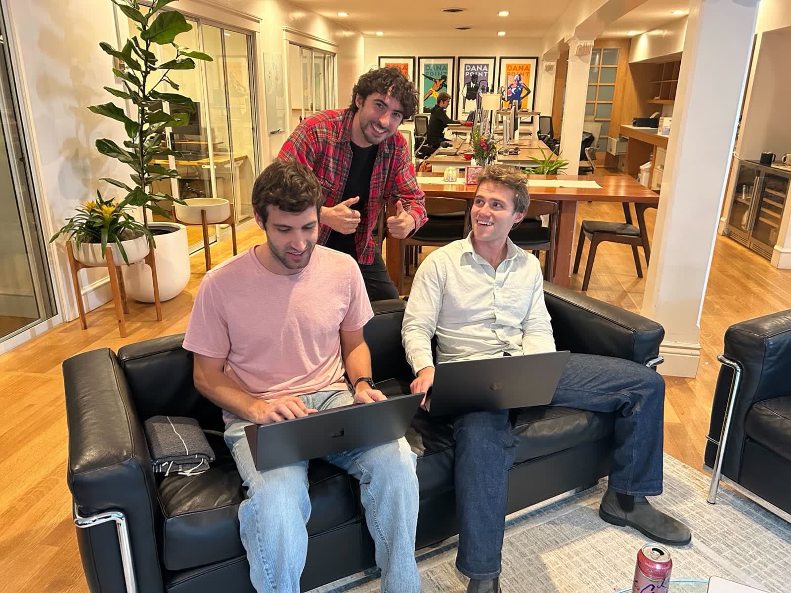 Avi gives a thumbs up while two early users try Superset on their laptops in their office